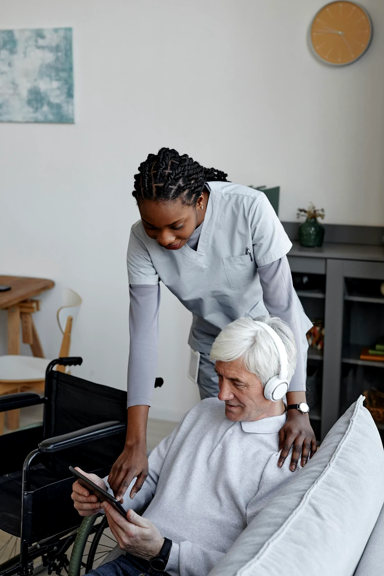 young woman helping old man with tool